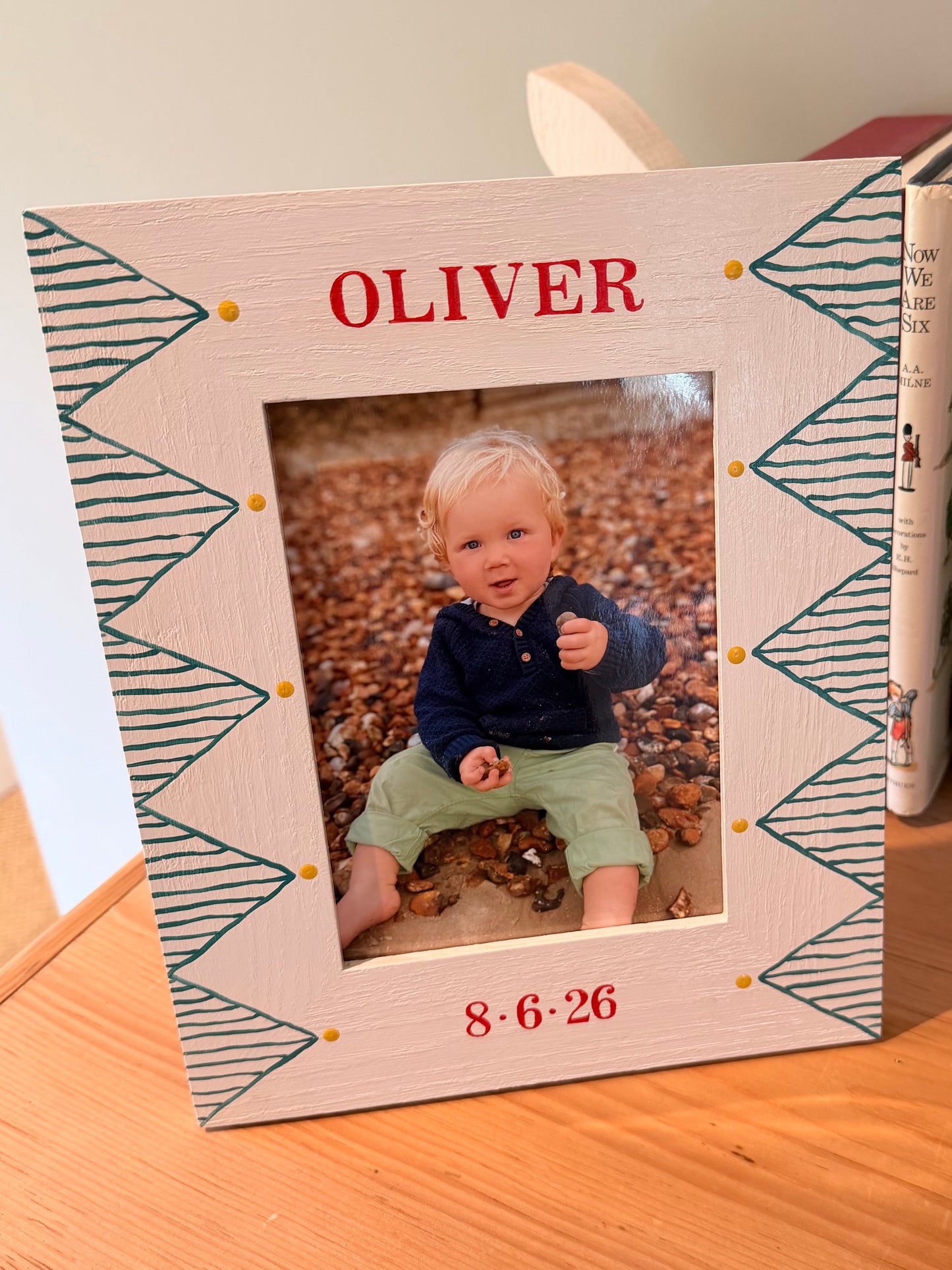 Wooden photo frame with zigzag pattern and a picture of a child, placed on a wooden surface.