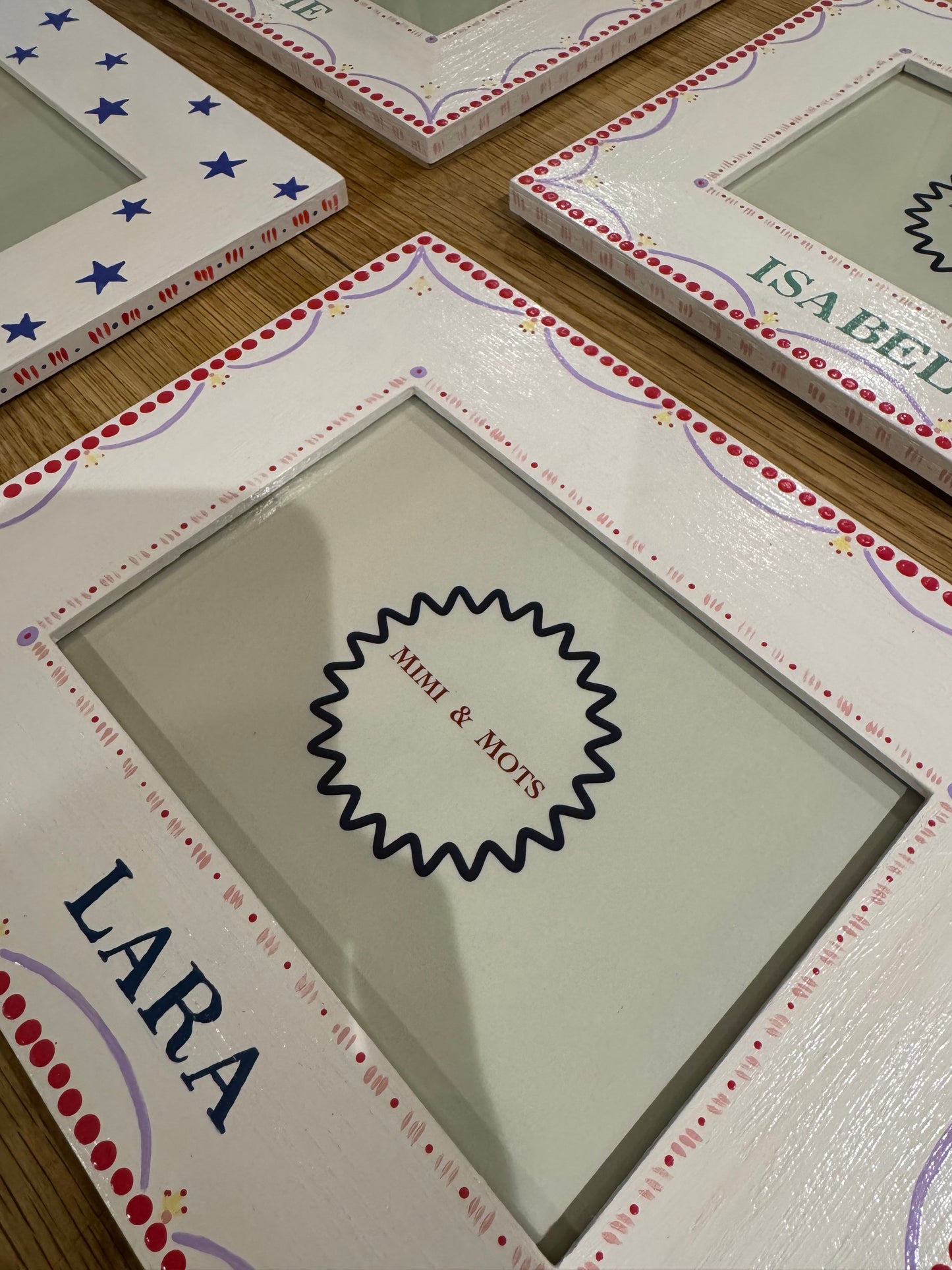 Decorative picture frames with 'Mimi & Mots' branding and personalised names.