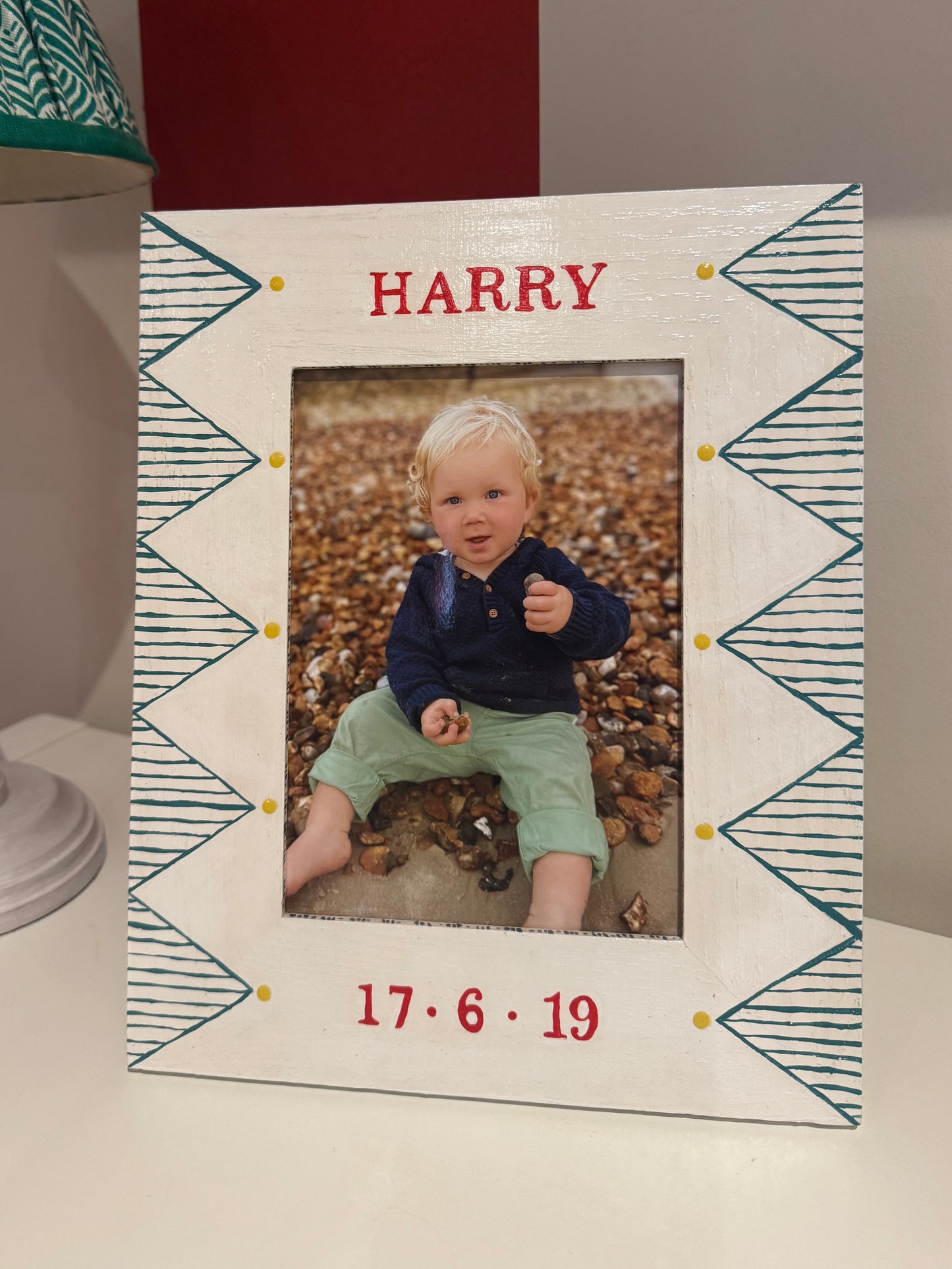Personalized photo frame with a child's picture and name 'Harry' on a textured surface.