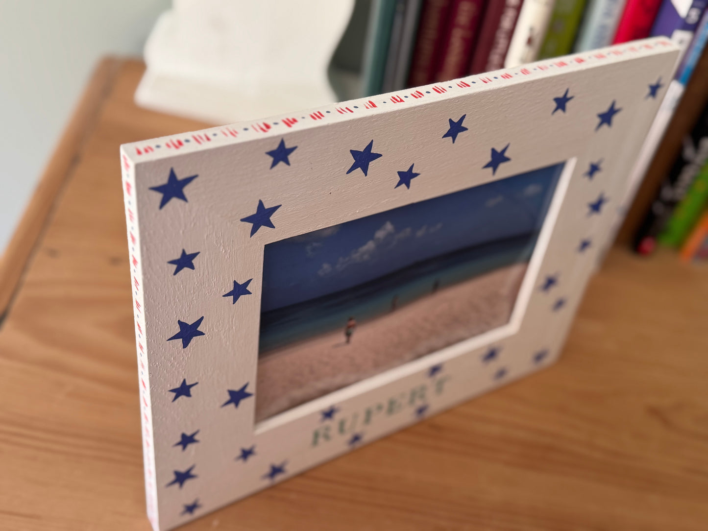 Close-up of personalised hand-painted white oak photo frame with blue stars and name in chosen colour — Star Photo Frame by Mimi & Mots