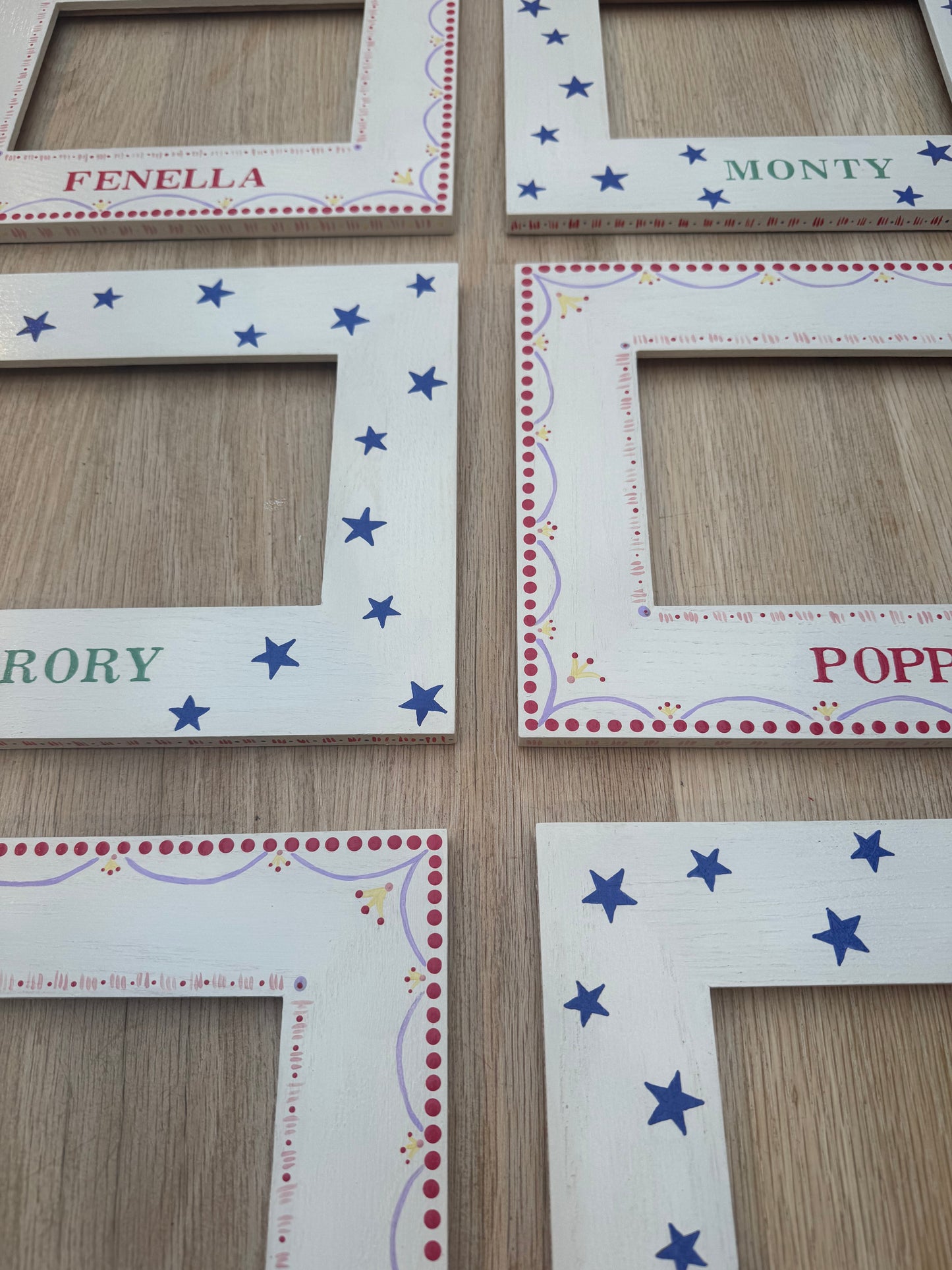 Set of decorative picture frames with names and star patterns on a wooden surface