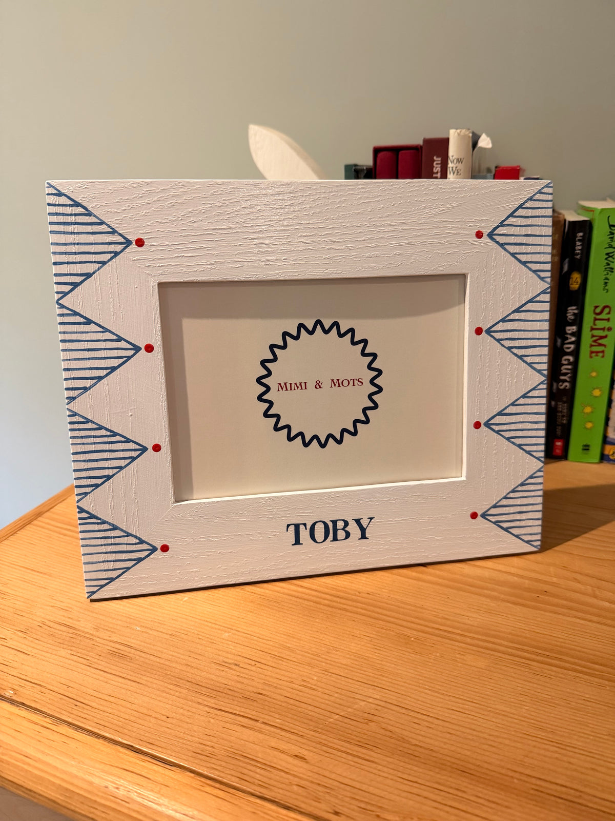 Geometric blue stripe photoframe with red detail in a Childs nursery. 